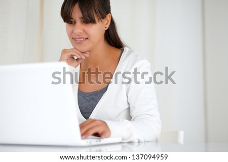 Portrait of a young woman browsing the internet on laptop computer