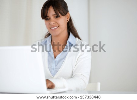 Portrait of a smiling young woman working on laptop computer - copy space