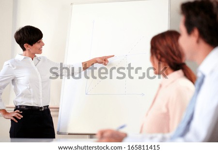 Portrait of a professional businesswoman working on a conference while standing and looking at white board
