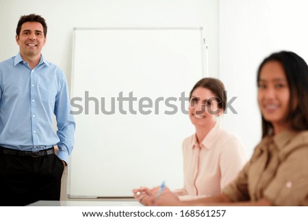 Portrait of an attractive professional group smiling and looking at you while working on a conference