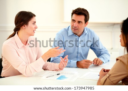 Female executive explaining a idea to colleagues while they listen and pay attention with much interest