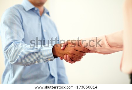 Portrait of professional couple coworkers giving hands greeting on closeup background