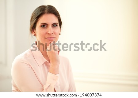 Portrait of pensive young businesswoman on pink blouse looking at you while standing on closeup background - copyspace