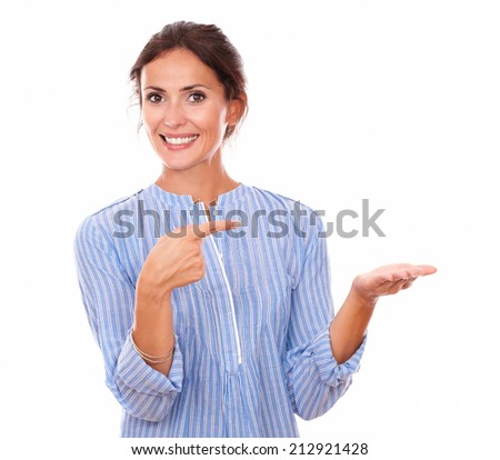 Portrait of 30s adult woman on blue blouse pointing to her left hand while holding her left palm up and smiling at you on isolated white background - copyspace