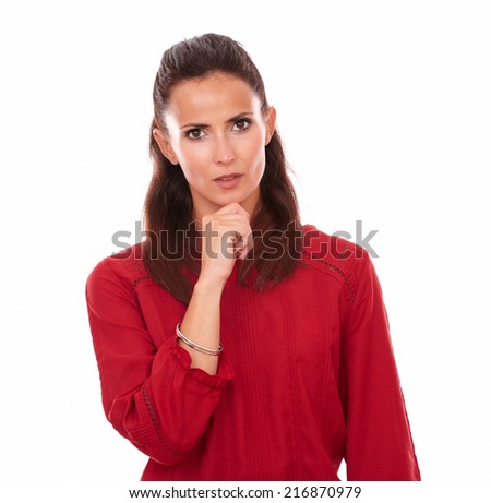 Portrait of pensive young woman on red blouse asking a question to herself while looking at you on isolated studio