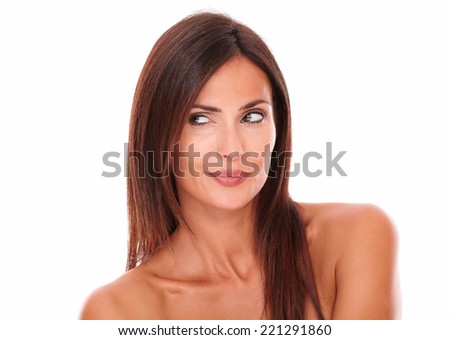 Head and shoulders portrait of pensive female with sexy smile looking to her right with nude shoulders on isolated white background - copyspace