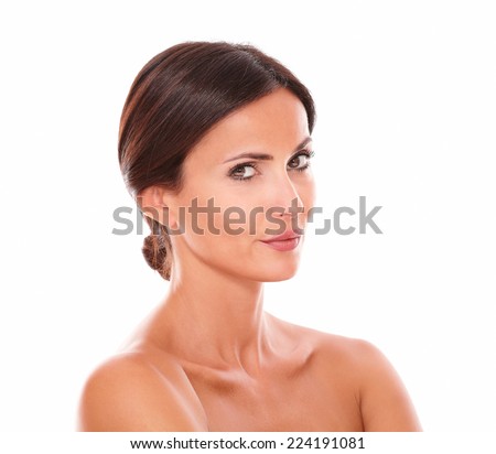 Head and shoulders portrait of beautiful sensual adult female wondering while looking at camera with nude shoulders on isolated studio