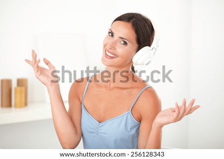 Smart latin woman with headphones looking relaxed while listening to music indoor
