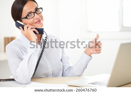 Latin employee with spectacles happily doing customer service in the company office