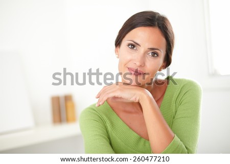 Elegant woman with natural beauty in green shirt smiling at her house - copyspace