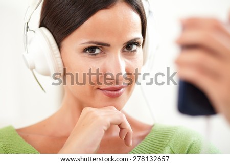 Attractive young woman with headphones looking at the camera - head and shoulders close-up