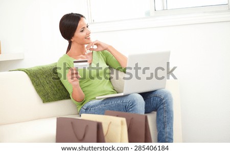 Carefree woman with straight hair using a credit card for electronic payment
