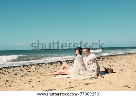couple very relax looking at the horizon on the beach