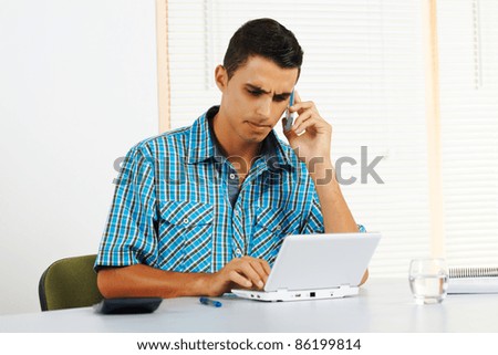 Young man with frustrated expression using a laptop.