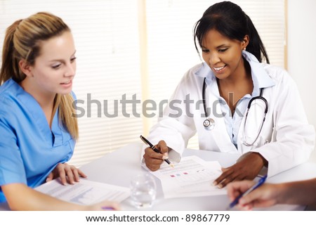 Portrait of a doctor talking on a meeting with two of his co-workers