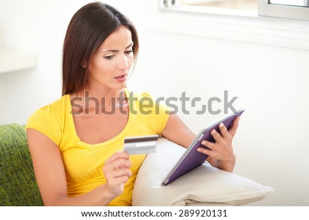 Beautiful woman planning to use a credit card for electronic payment from home