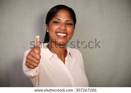 Young businesswoman in her 20s making a good job gesture while smiling at the camera