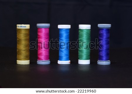 five spools of thread in different colors