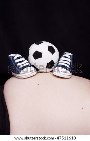 sports shoes and a ball above the belly of a mother