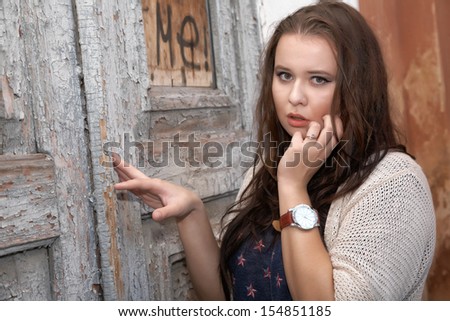 Beautiful plus size woman expresses delight against an old door