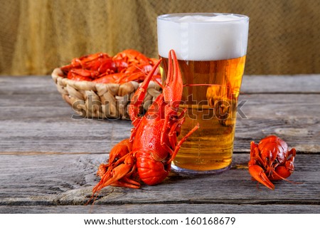 Tasty boiled crayfishes and beer on old table