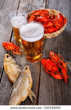 Tasty boiled crayfishes vyaleny fish and beer on old table