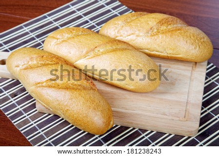 Three long loafs  on a chopping board