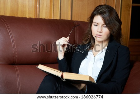 The girl in a suit reads the book