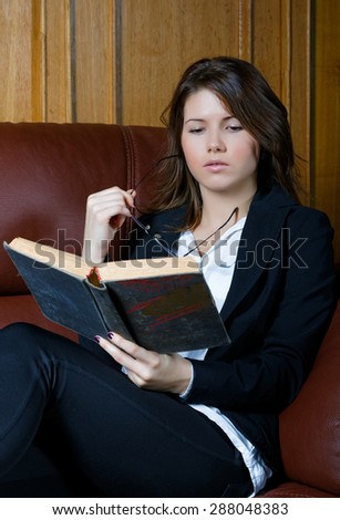 The girl in a suit reads the book