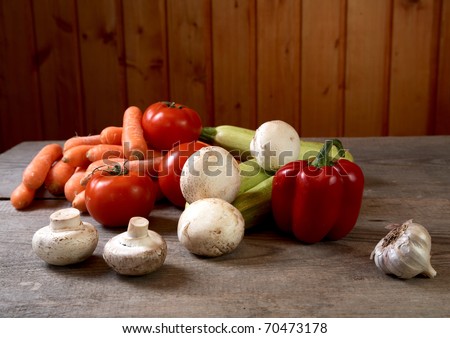 Mushrooms and vegetables on a table from unplaned boards
