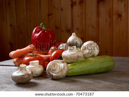 Mushrooms and vegetables on a table from unplaned boards