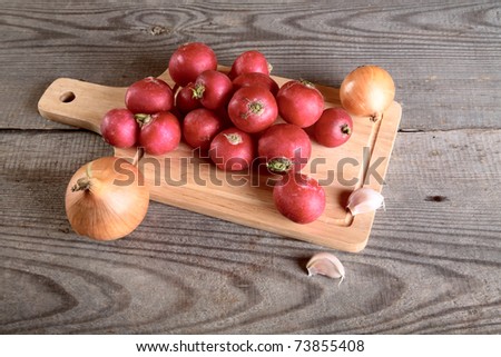 Onions garlic  garden radish on a table from unplaned boards