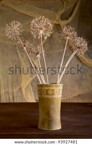 Still-life with dry flowers in a wooden vase