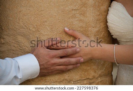 Groom and bride holding hands during weding photography session