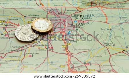 One Euro coin and old Cyprus Cents on a map. Concept of financial crisis in Cyprus.