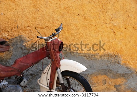 Vintage motorbike against a yellow wall