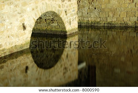 Castle bridge reflected on water from Paphos medieval castle in Cyprus