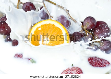 Splashing milk with fruit and berry