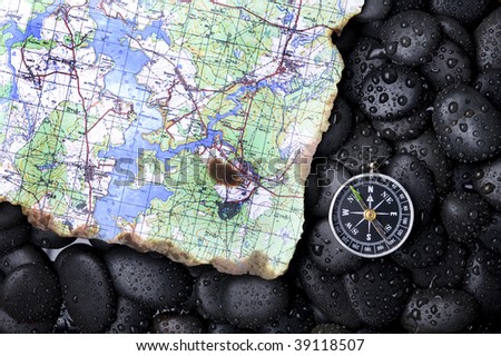 Compass with rock cover water and map