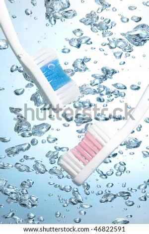 Toothbrush on creative background with blue water bubbles