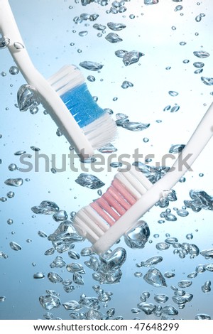 Toothbrush on creative background with blue water bubbles