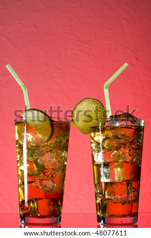 Cocktail with and ice.  Drink on red background