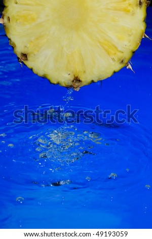 Pineapple with splashing  clear water on blue background