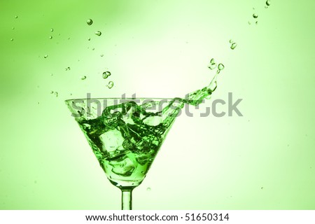 Splashing green cocktail in martini glass
