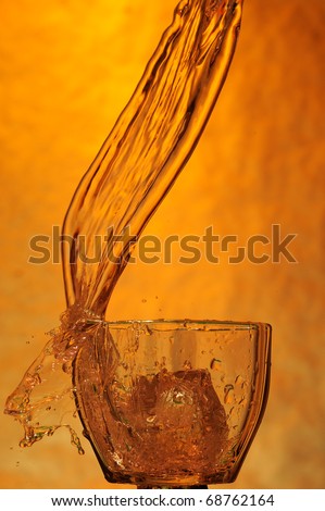 Whisky and ice. Splashing scotch on brown background