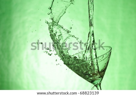 Martini glass with stream fresh drink. Splashing cocktail