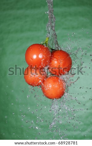 Red sweet tomato and fresh splashing water