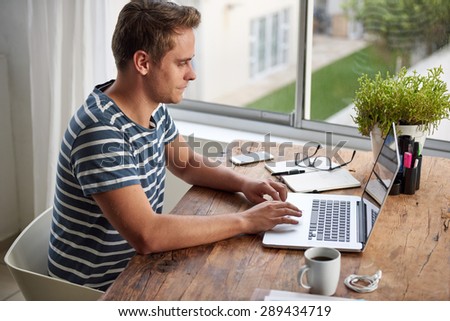 High angle shot of a creative young freelancer working on his laptop at his desk in his home office