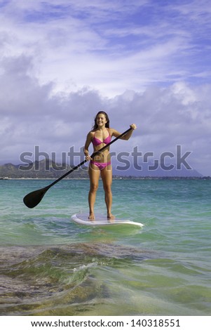 beautiful blonde in bikini on paddle board