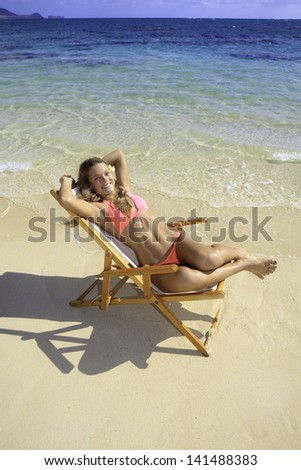 blond in bikini on a beach chair by the ocean